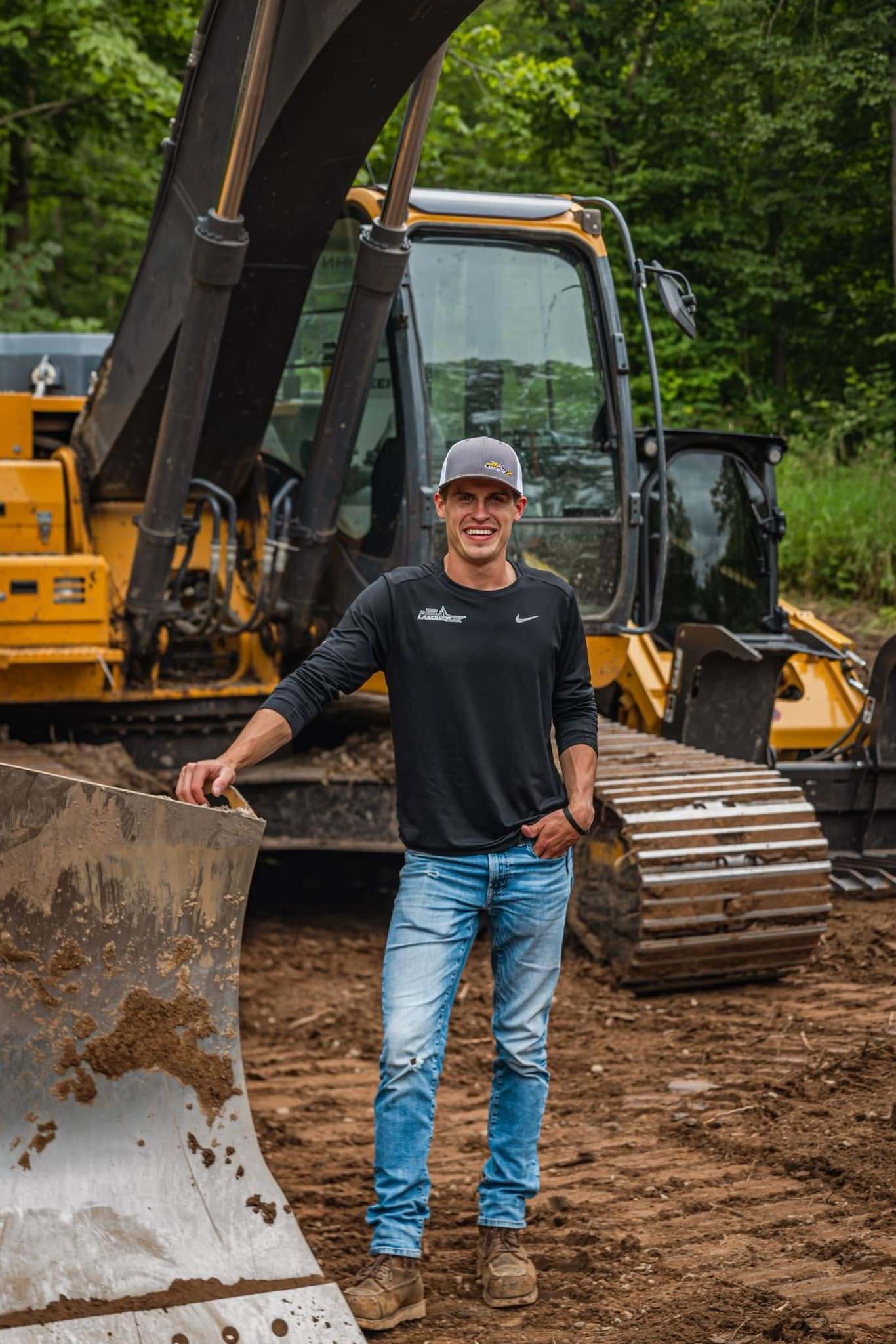 Jordan LaVine, owner of JL Landworx, in front of company excavation equipment
